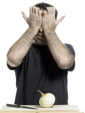 Homem chorando ao cortar cebola